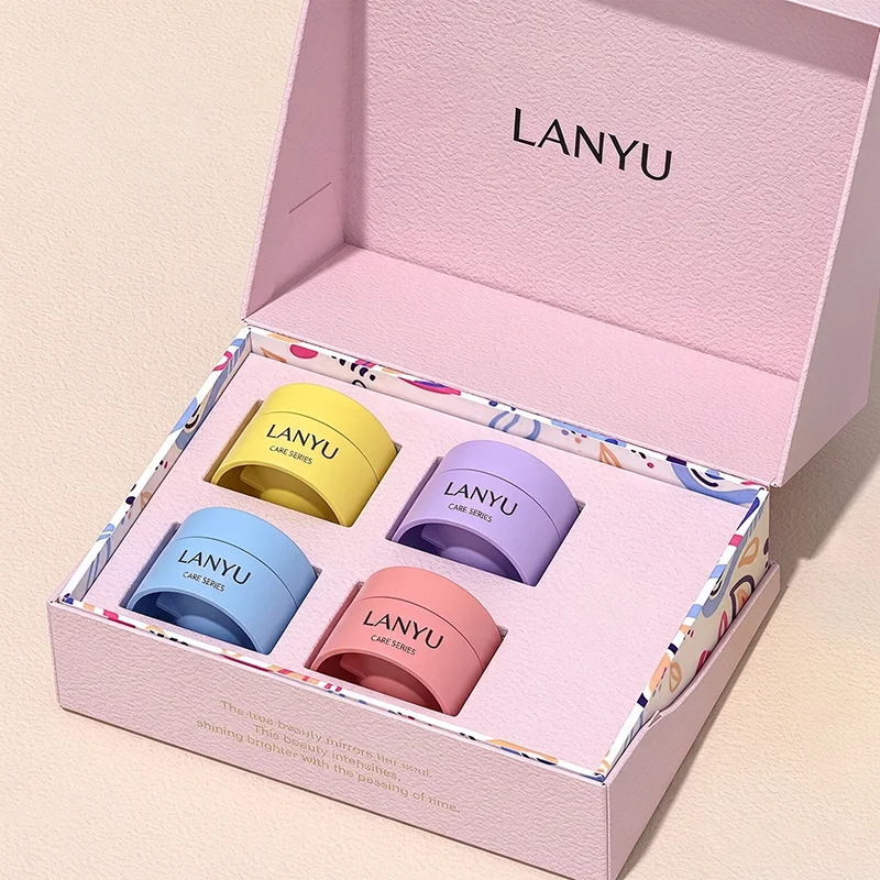 Pink gift box holding four colored cosmetic jars in fitted cutouts